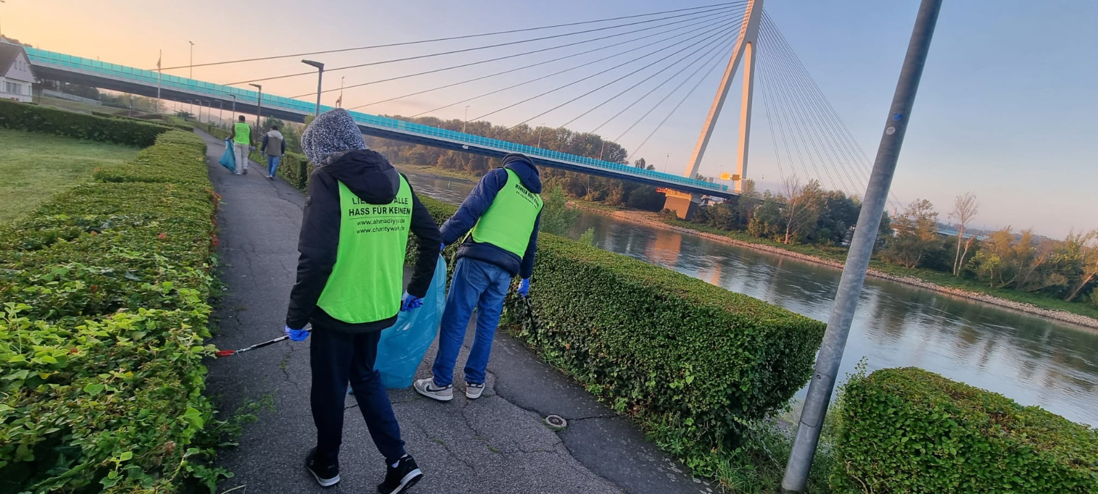 Freiwillige beim World Cleanup Day am Rheinufer in Neuwied mit der Rheinbrücke im Hintergrund